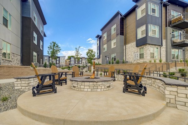 Cozy fire pit area with seating at Broadstone Wren Apartments, ideal for relaxation and social gatherings in a luxury setting