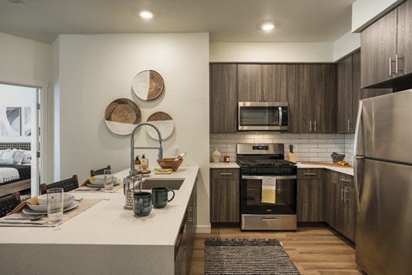 Modern kitchen with stainless steel appliances at Allaso Journal Center Apartments
