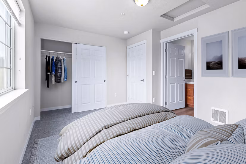 Cozy bedroom with modern decor and ample natural light at Trillium Apartments, the perfect blend of luxury and comfort living