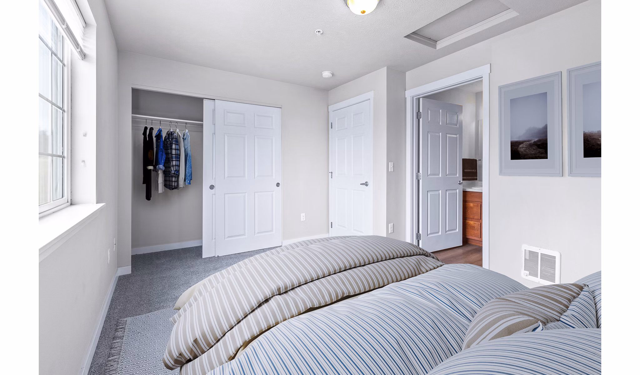 Cozy bedroom with modern decor and ample natural light at Trillium Apartments, the perfect blend of luxury and comfort living