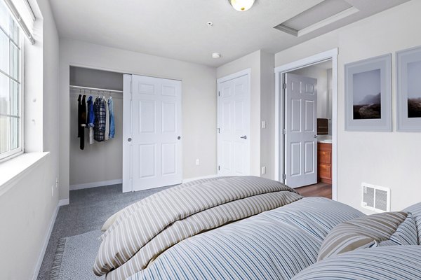 Cozy bedroom with modern decor and ample natural light at Trillium Apartments, the perfect blend of luxury and comfort living