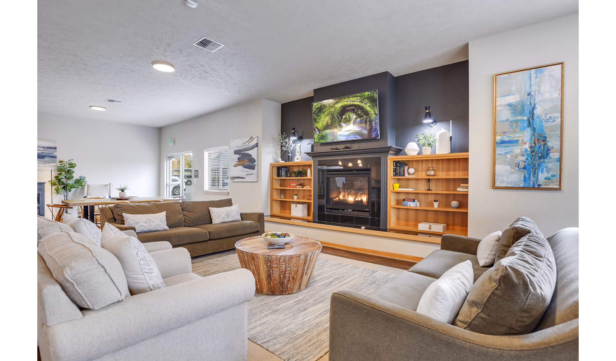 Clubhouse featuring modern lounge seating and a cozy fireplace at Trillium Apartments, a Greystar luxury community