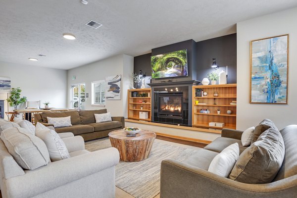 Clubhouse featuring modern lounge seating and a cozy fireplace at Trillium Apartments, a Greystar luxury community