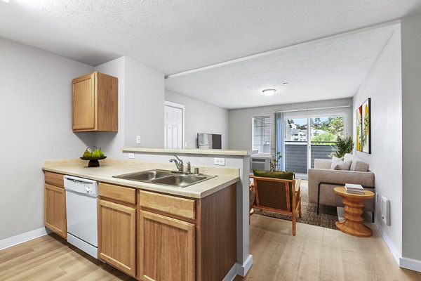 Modern kitchen featuring stainless steel appliances and quartz countertops in Trillium Apartments