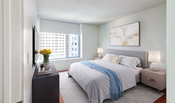 Modern bedroom with large windows and stylish decor at Radian Apartments, offering luxury living in a prime location