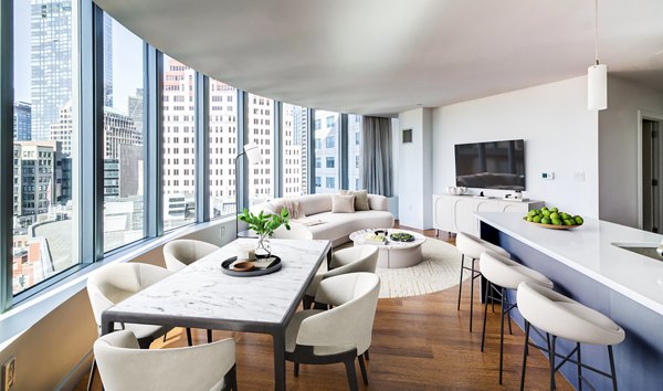 Spacious living room with modern decor and large windows in Radian Apartments