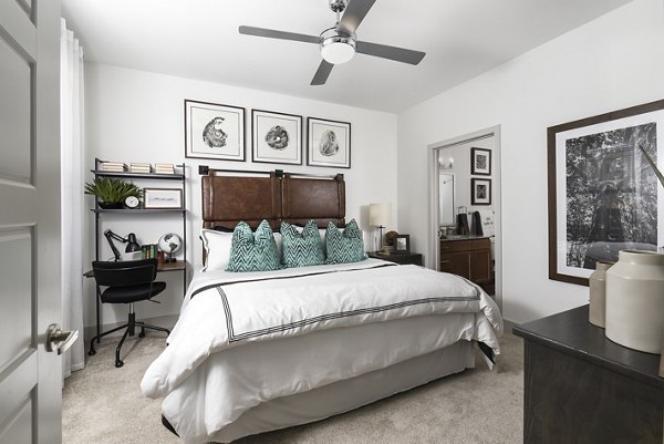 Cozy bedroom with modern decor and ample natural light at Austin Avenue Apartments