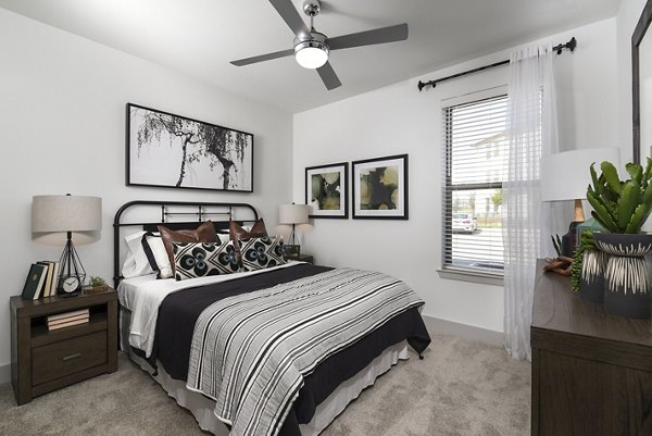 Cozy bedroom with modern furniture and vibrant accents at Austin Avenue Apartments