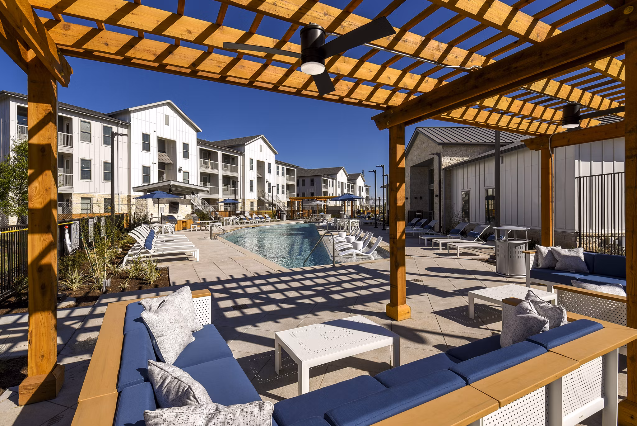 Patio space with modern seating and garden views at Austin Avenue Apartments