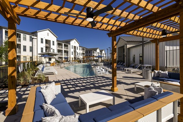 Patio space with modern seating and garden views at Austin Avenue Apartments