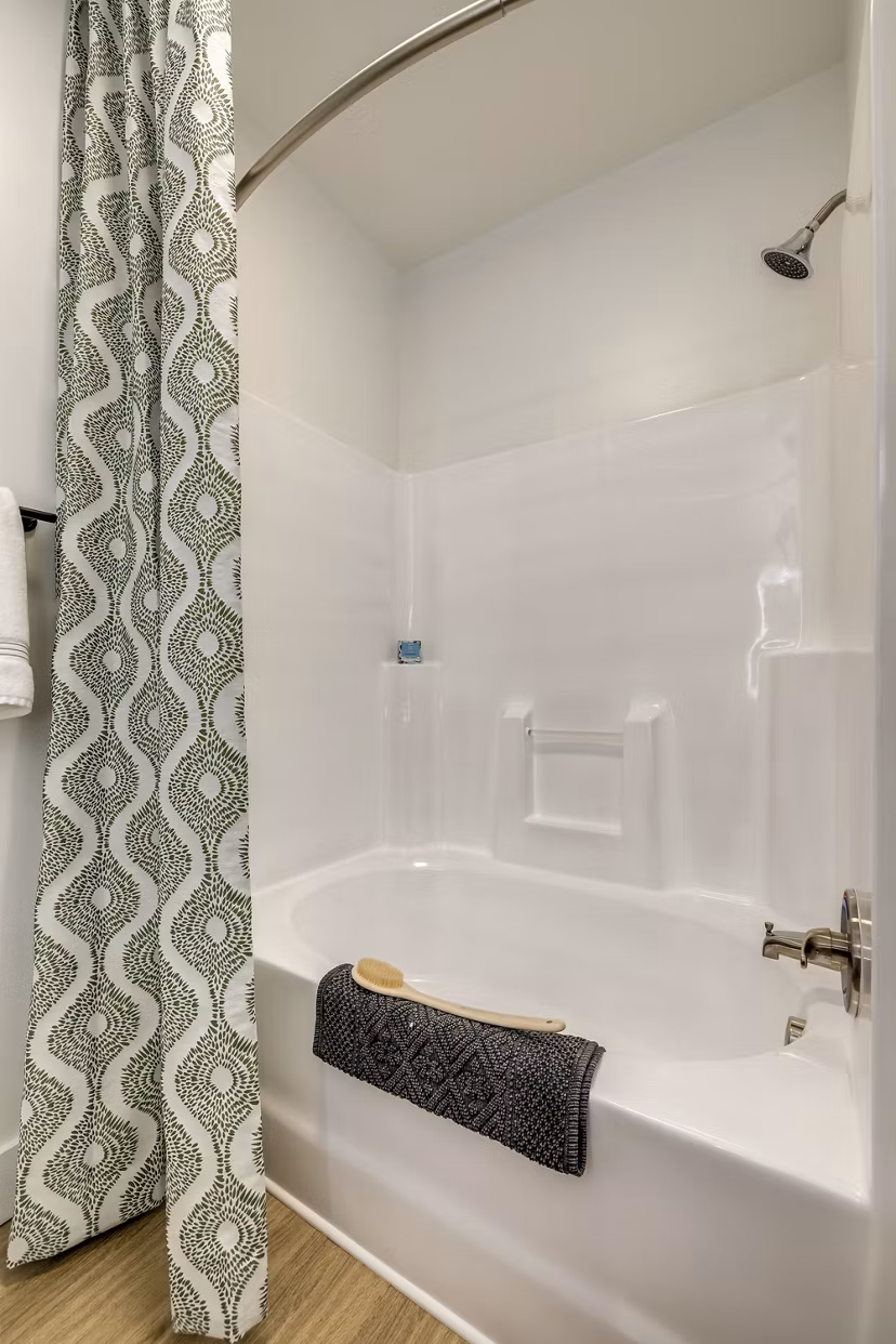 Modern bathroom featuring sleek fixtures and a glass-enclosed shower at The Banks at Rivergate Apartments