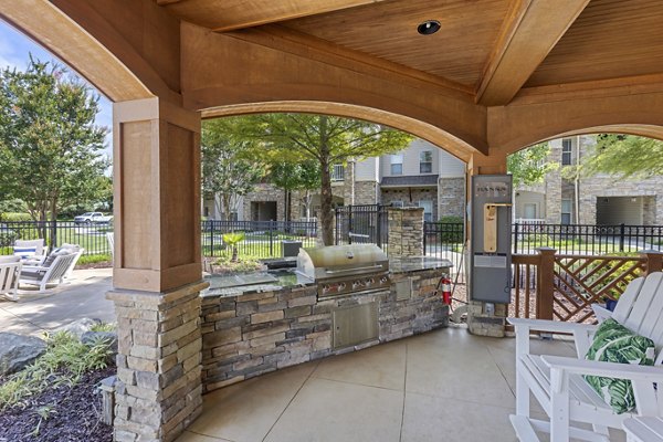 Outdoor grill area with modern seating at The Banks at Rivergate Apartments, offering a luxurious dining experience for residents
