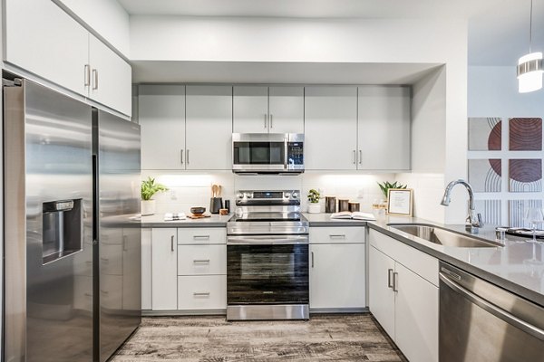 Modern kitchen with stainless steel appliances at Esperanza at Duarte Station Apartments