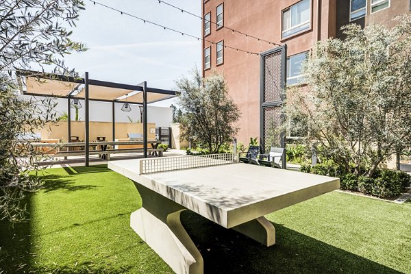 Outdoor grilling area at Esperanza at Duarte Station Apartments with modern patio seating for recreation and relaxation