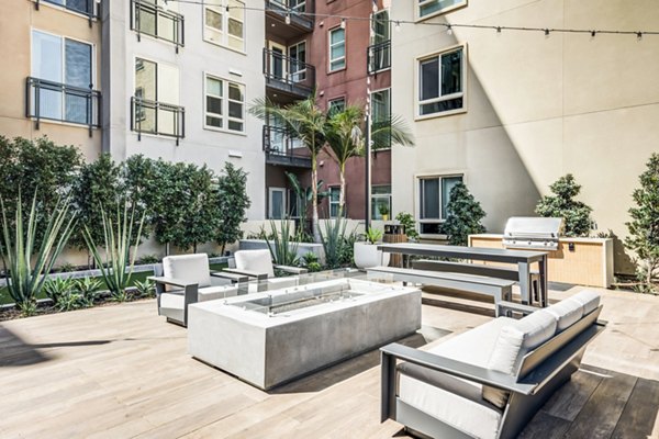 Grill area and patio with modern furniture at Esperanza at Duarte Station Apartments