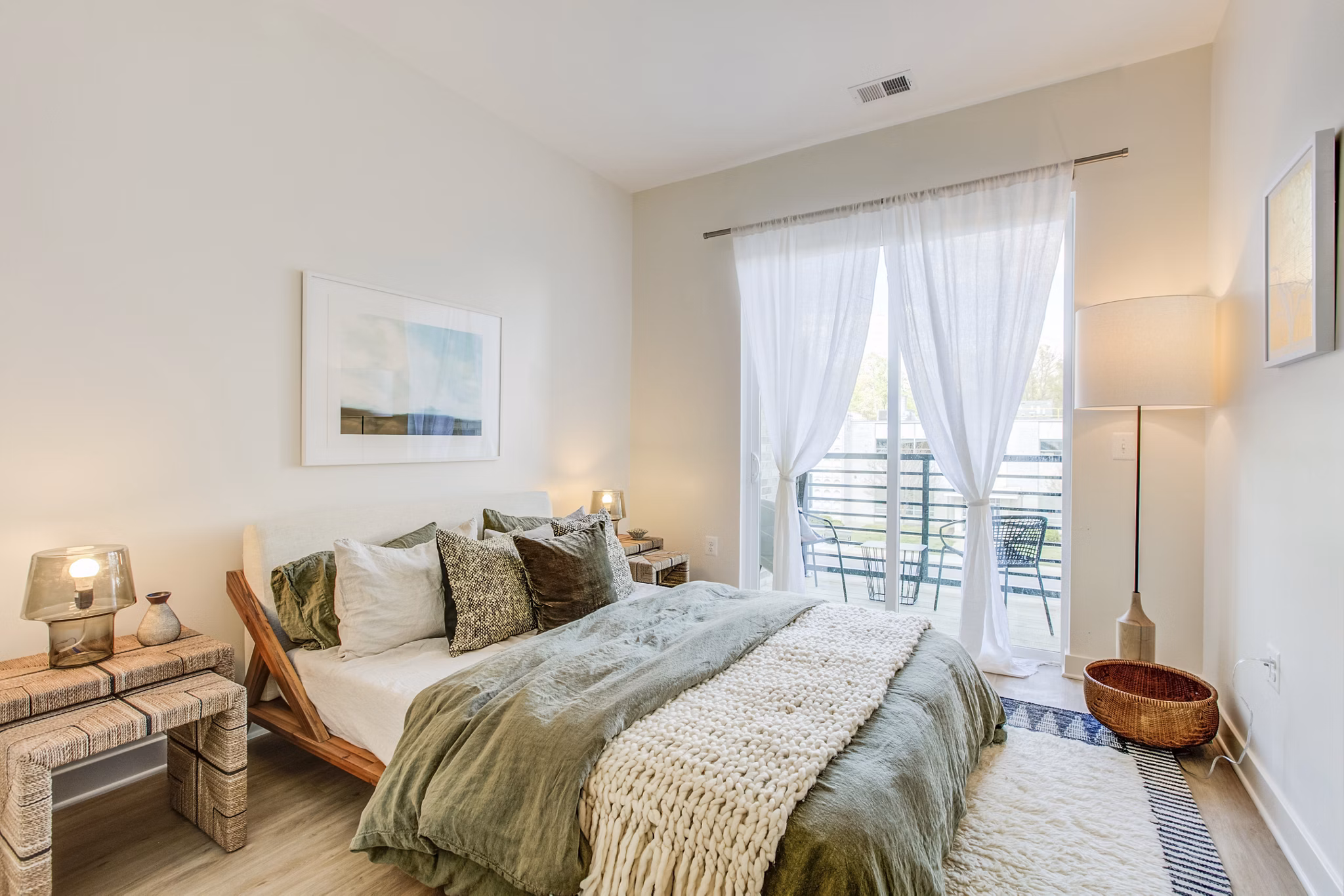 Cozy bedroom with modern decor at Centro Arlington Apartments, featuring plush bedding and ample natural light