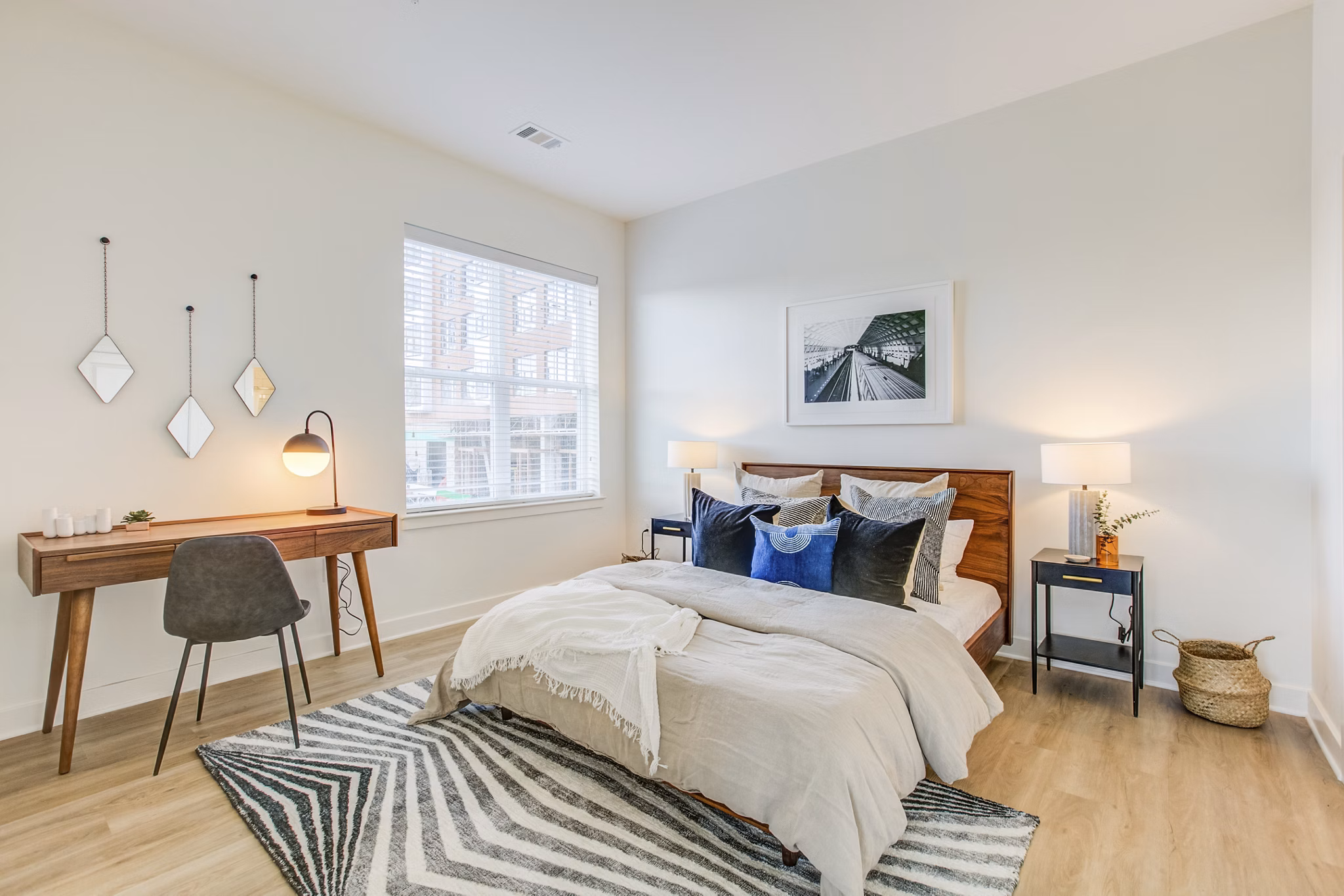 Cozy bedroom with modern furnishings at Centro Arlington Apartments, featuring a large window and neutral palette for a serene living space