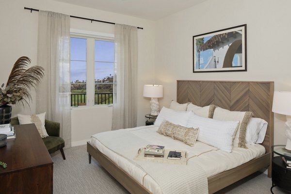 Bedroom with modern decor and large windows at Everleigh San Clemente Apartments