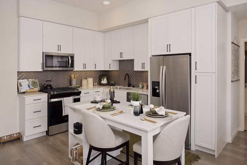 Modern kitchen with stainless steel appliances and island counter in Everleigh San Clemente Apartments
