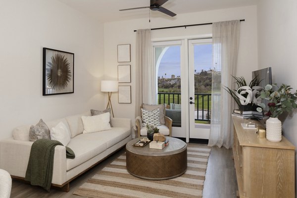Spacious living room with modern decor and ocean views at Everleigh San Clemente Apartments