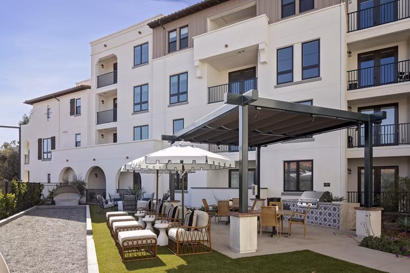 Courtyard with lush greenery and seating area at Everleigh San Clemente Apartments, a luxury community by Greystar