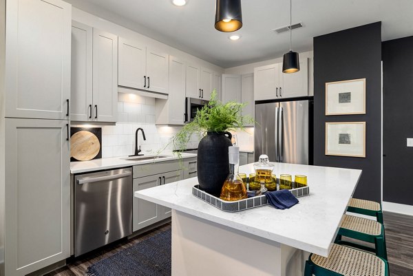 Modern kitchen with stainless steel appliances and marble countertops at The Signal Apartments