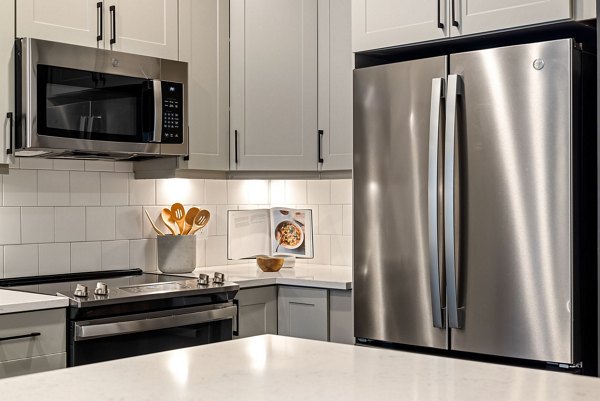 Modern kitchen with stainless steel appliances in The Signal Apartments