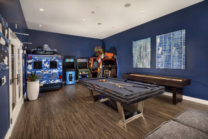 Game room with billiards table and cozy seating at Next on Lex Apartments in Glendale