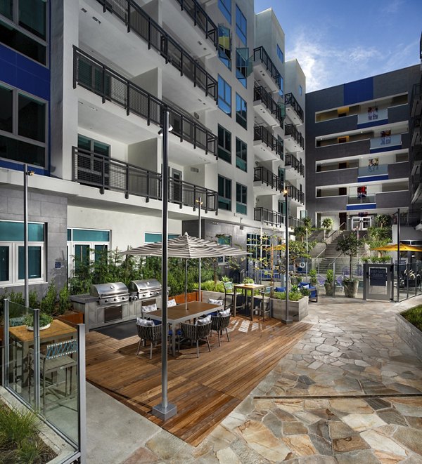 Outdoor grill area with modern appliances at Next on Lex Apartments, ideal for gatherings and barbecues in a luxury setting