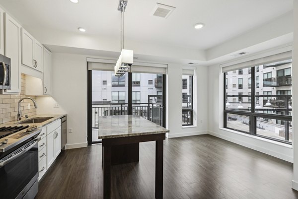 Modern kitchen with stainless steel appliances and quartz countertops in Avidor Edina Apartments