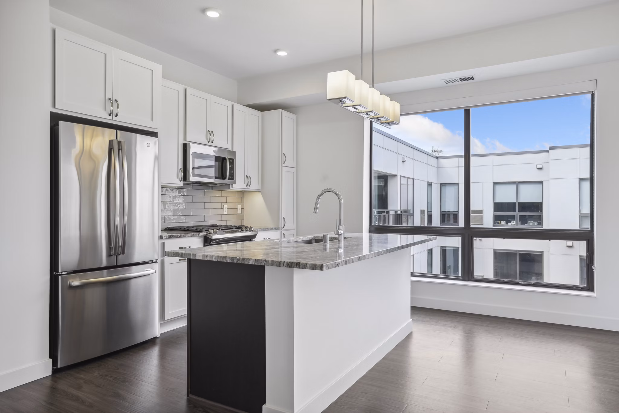 Modern kitchen with stainless steel appliances and spacious countertops at Avidor Edina Apartments in Edina, MN