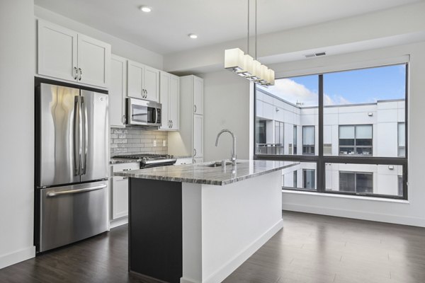 Modern kitchen with stainless steel appliances and spacious countertops at Avidor Edina Apartments in Edina, MN