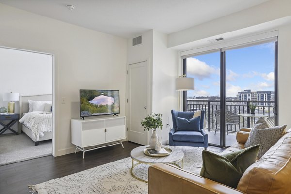 Spacious living room with modern furnishings in Avidor Edina Apartments
