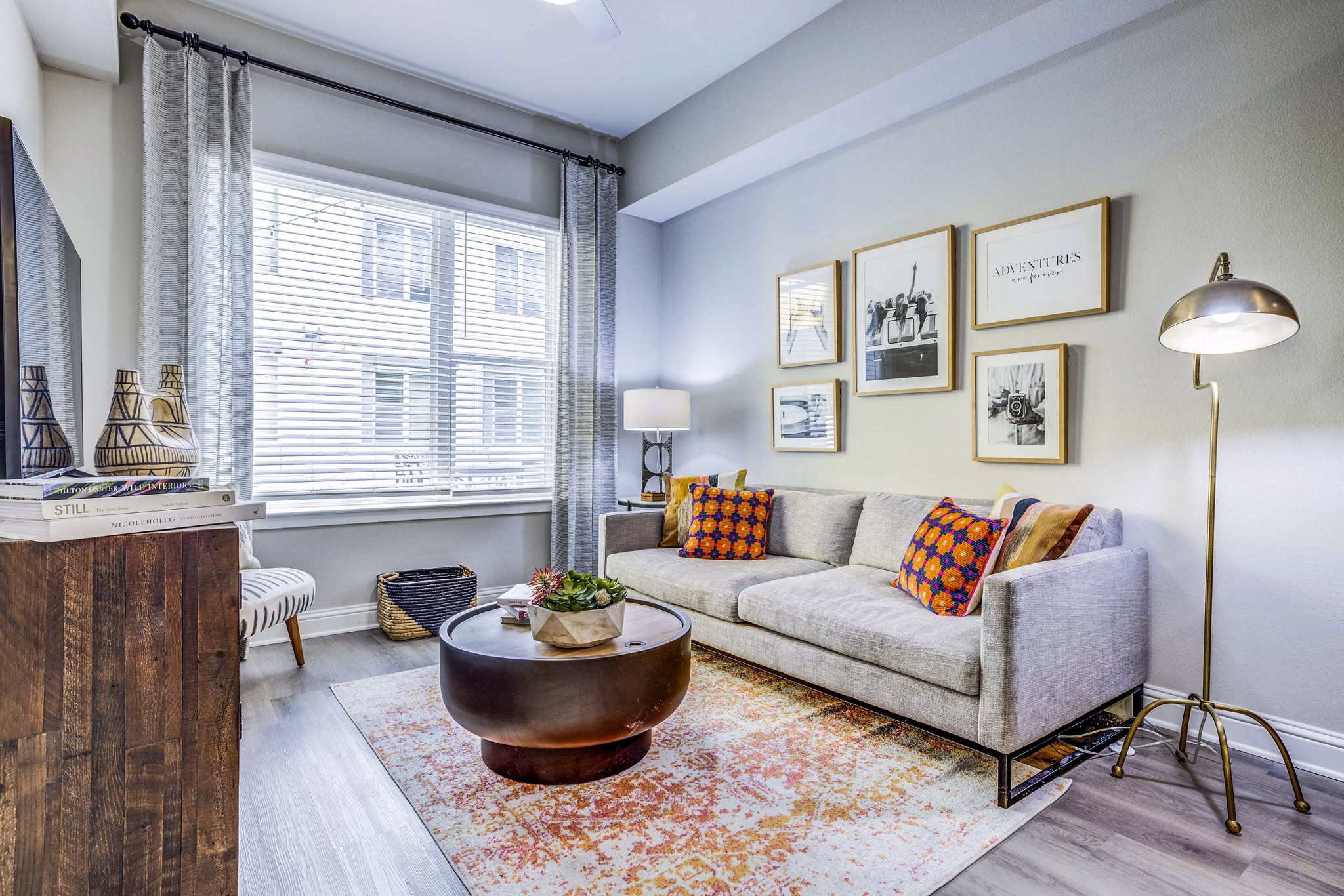 Modern living room with sleek furnishings in Zoey Apartments, featuring large windows for natural light
