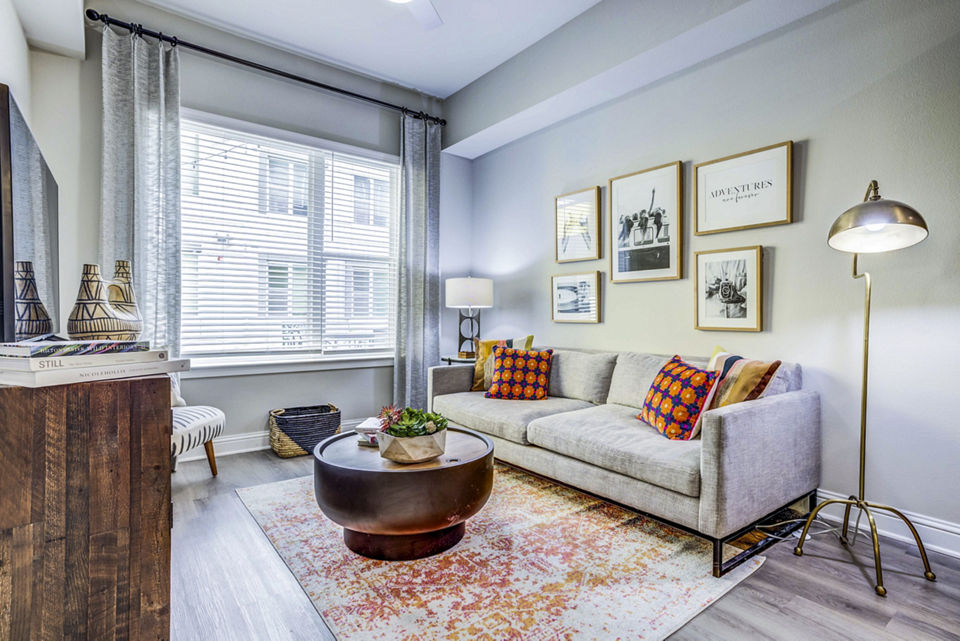 Modern living room with sleek furnishings in Zoey Apartments, featuring large windows for natural light