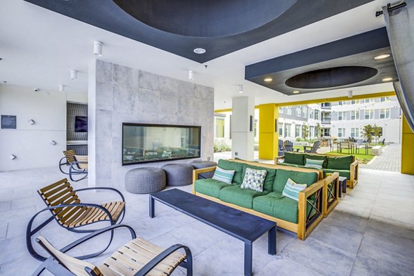 Cozy outdoor fire pit and seating area on the patio at Zoey Apartments