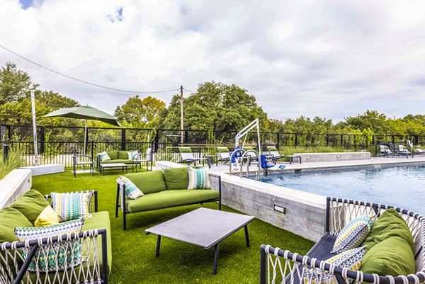 Luxury poolside view at Zoey Apartments: Modern swimming pool with cabanas and sun loungers, offering resort-style relaxation in Greystar community