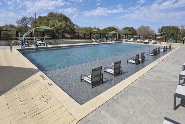 Resort-style pool with sun loungers at Zoey Apartments