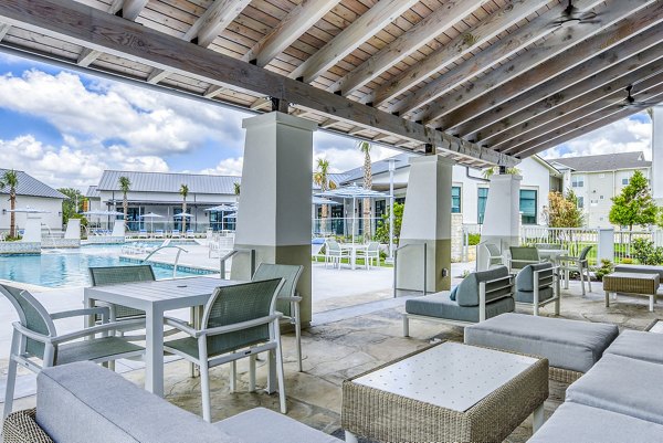 Outdoor pool with lounge chairs at Tacara Dove Creek Apartments, offering a luxurious relaxation space for residents