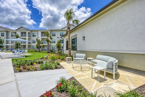 Chic patio space with modern seating and lush greenery at Tacara Dove Creek Apartments