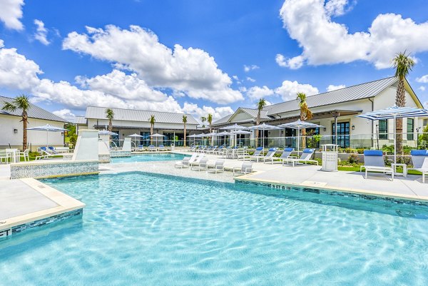 Resort-style pool at Tacara Dove Creek Apartments with luxury seating and palm trees, ideal for relaxation and entertainment