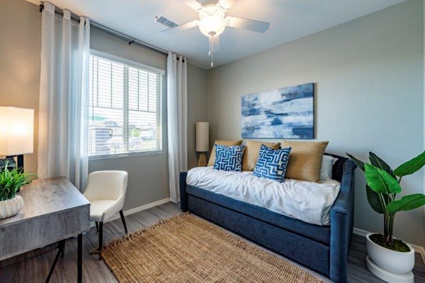 Bedroom with plush bedding and modern decor at Vlux at Sunset Farms Apartments, luxurious living in a serene setting