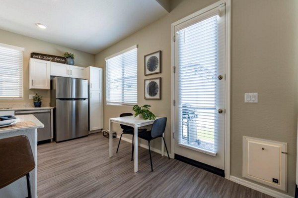 Dining room with elegant wooden table and modern lighting at Vlux at Sunset Farms Apartments
