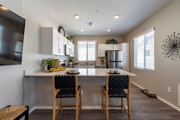 Modern kitchen with stainless steel appliances at Vlux at Sunset Farms Apartments, a Greystar community