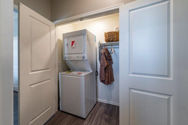 Modern laundry room with efficient appliances at Vlux at Sunset Farms Apartments