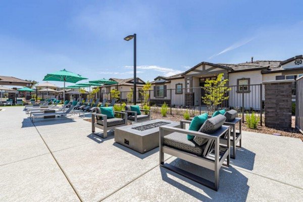 Outdoor fire pit area at Vlux at Sunset Farms Apartments providing a cozy, social atmosphere for residents to gather and relax