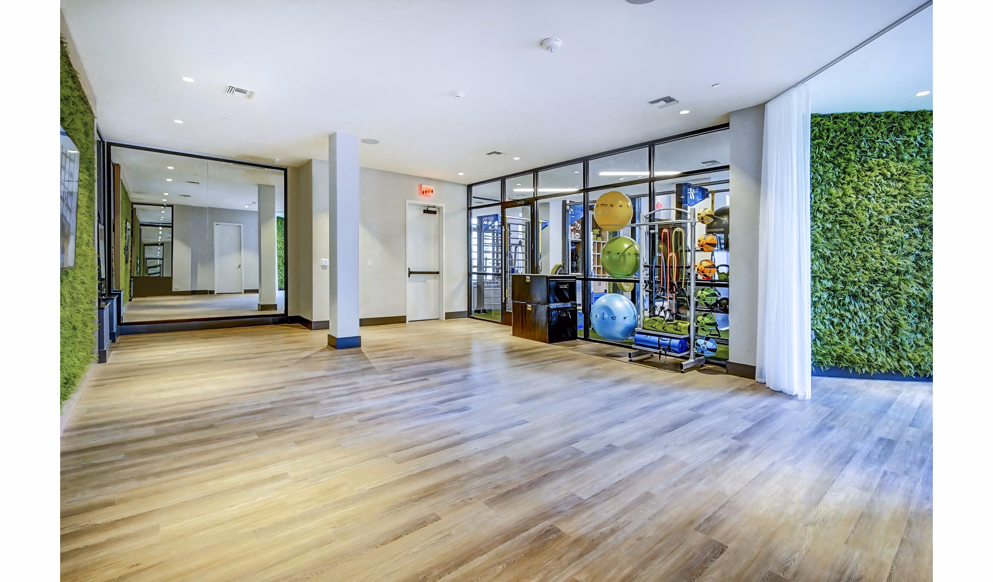 Yoga studio featuring full-length mirrors and hardwood floors at The Ellsworth Apartments