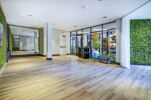 Yoga studio featuring full-length mirrors and hardwood floors at The Ellsworth Apartments