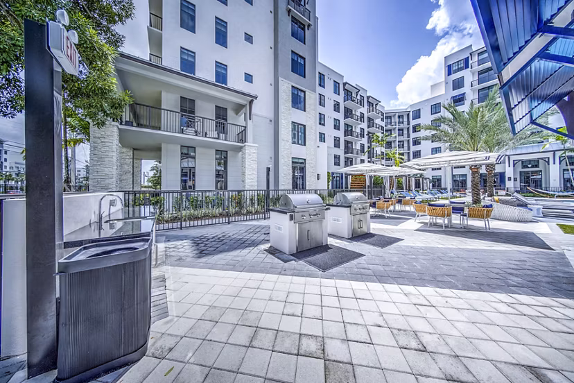 Outdoor grill area and patio at The Ellsworth Apartments, featuring modern seating and cooking facilities