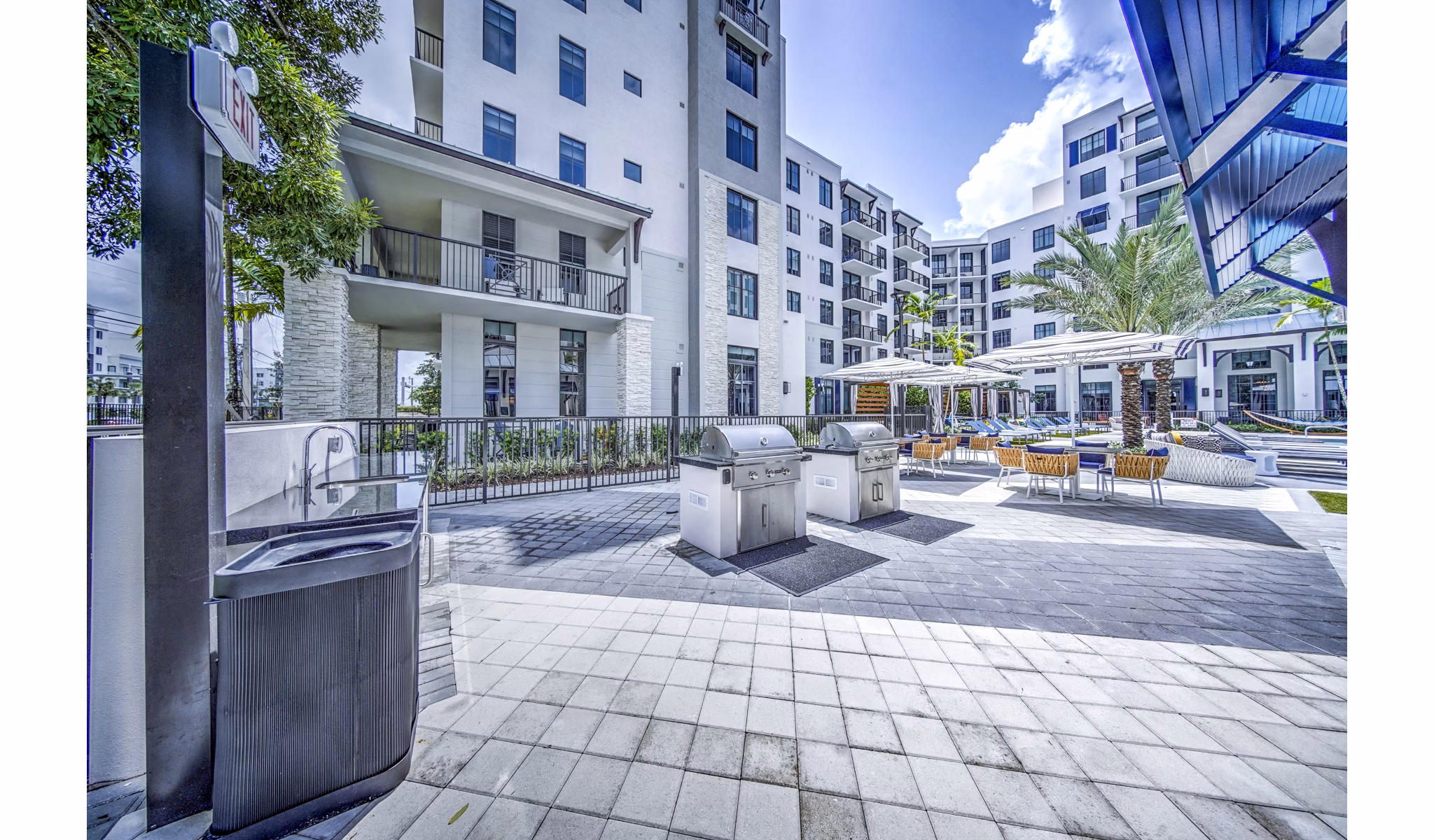 Outdoor grill area and patio at The Ellsworth Apartments, featuring modern seating and cooking facilities